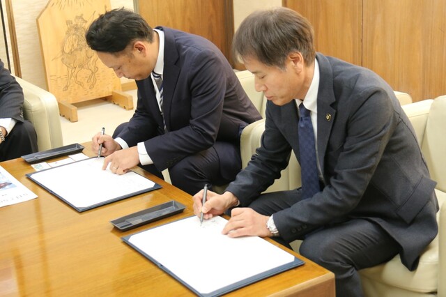 協定書にサインしている様子