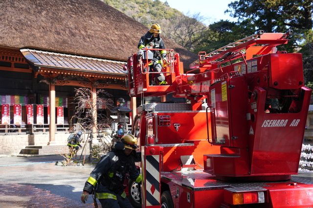 はしご付き消防ポンプ車で放水の準備をする様子