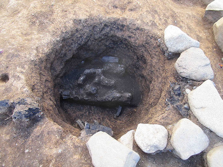 写真9　子易・中川原遺跡:中世石組墓下部土坑人骨・炭化物検出状況（東から）